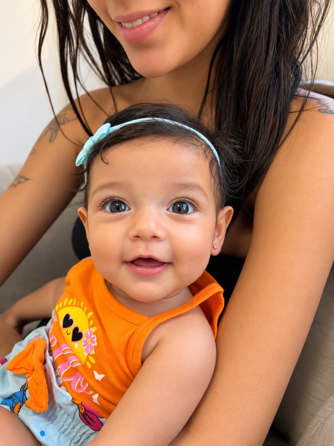 Close-up delicado de orelhinha de bebê com brinco pequeno e hipoalergênico